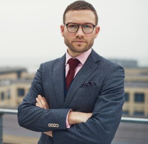 Serious businessman leaning against railing